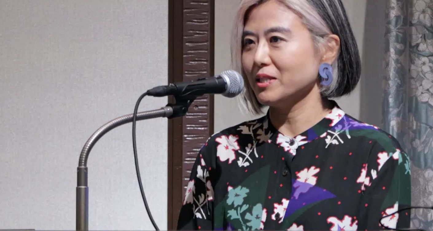 マイクの前で講演するbestat代表取締役CEO 松田尚子さん