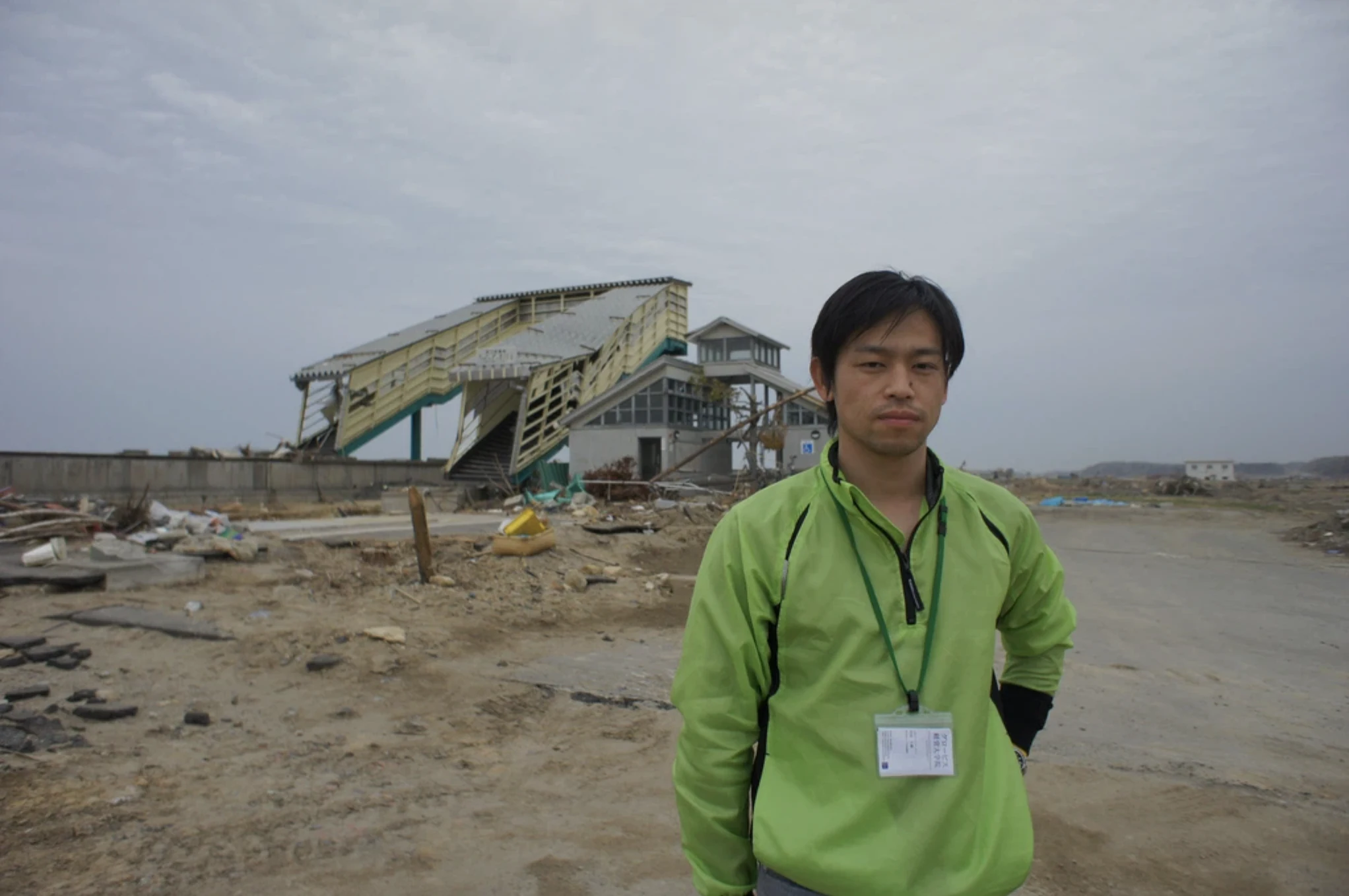 東日本大震災後の坂元駅前に立つ岩佐大輝さん